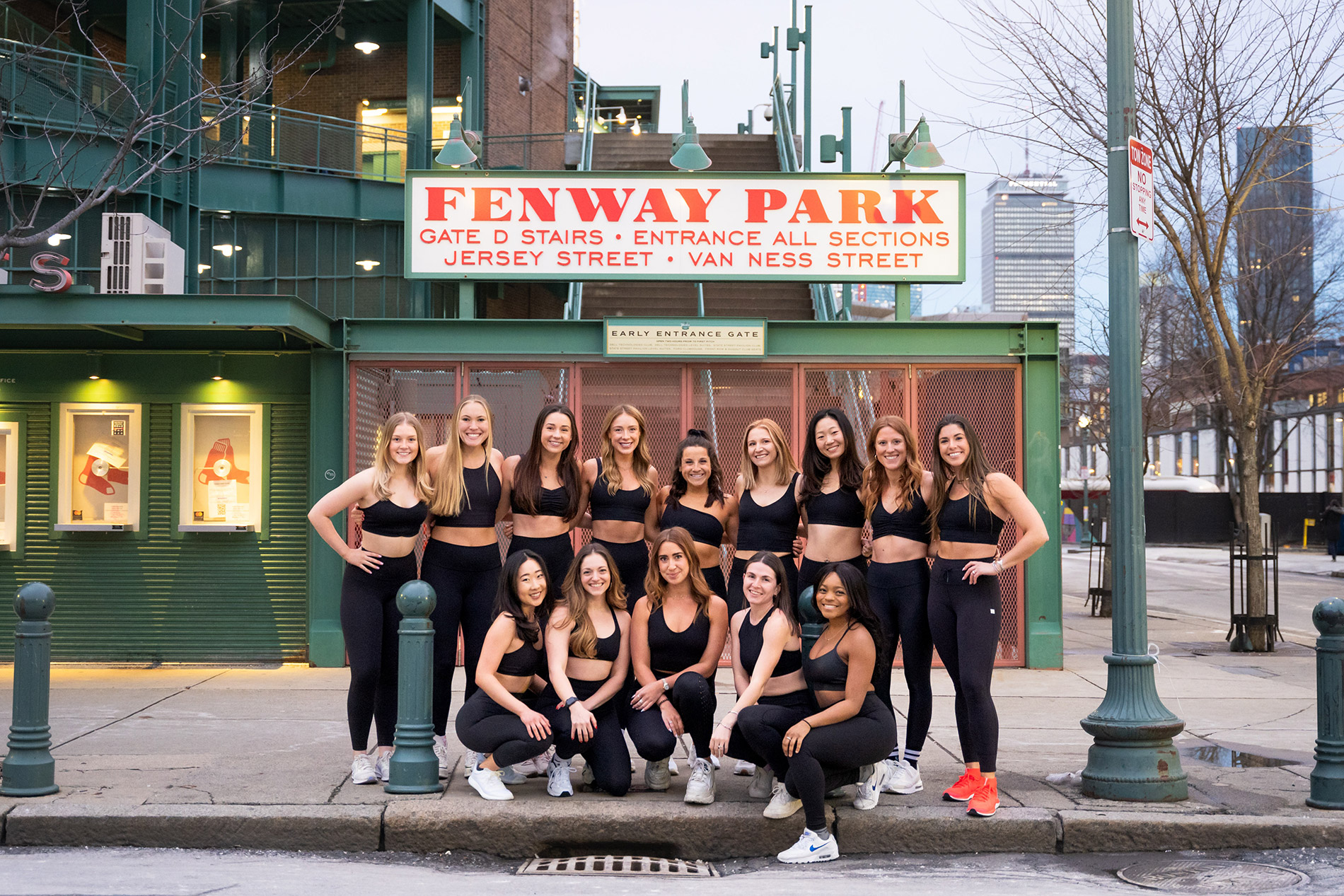 The staff from solidcore fitness studio pose for a group photo outside of Fenway Park baseball stadium in Boston.