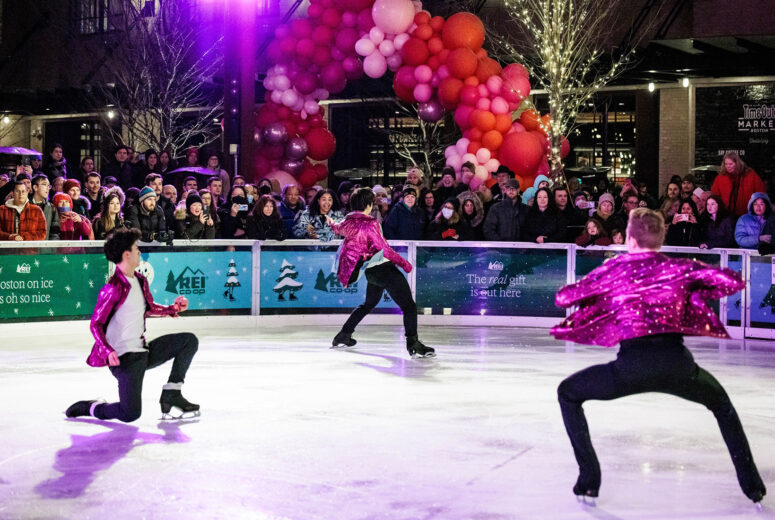 A group of people performing on an ice rink in front of a crowd.