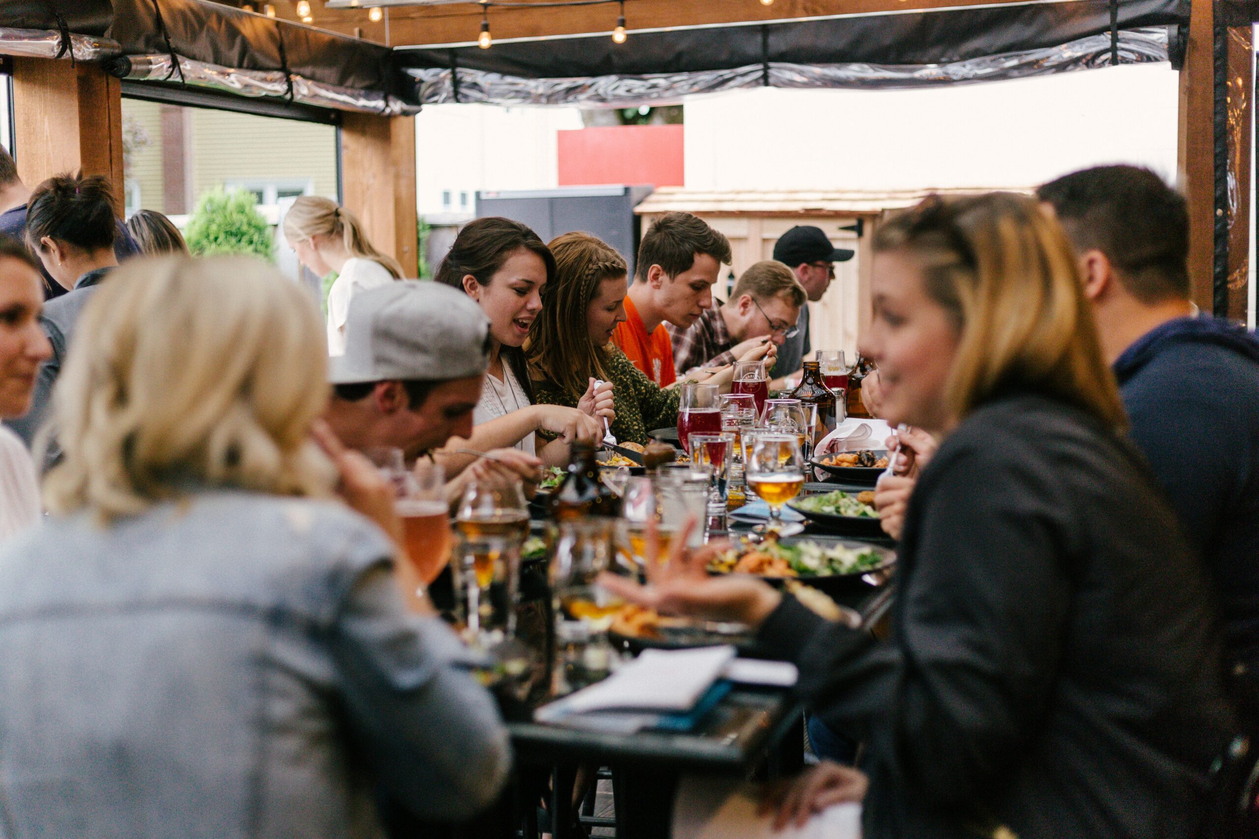 Diners sit at a community-style table and eat pub-style food and converse with each other.
